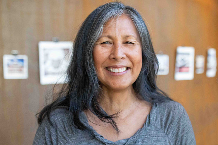 Attractive older woman with long dark hair smiling at the camera