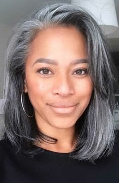 Attractive African-American woman with gray hair, wearing a black shirt, smiling at the camera