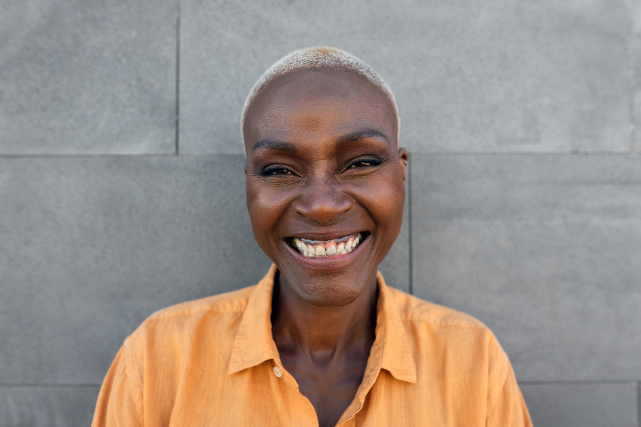 Attractive woman with grey hair wearing an orange shirt